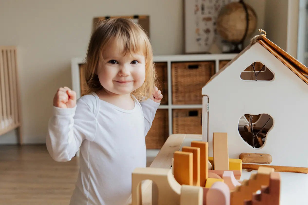 Joaca și învățarea merg mână în mână! 🌿 O fetiță fericită explorează lumea Montessori cu jucării educative perfecte pentru vârsta ei.